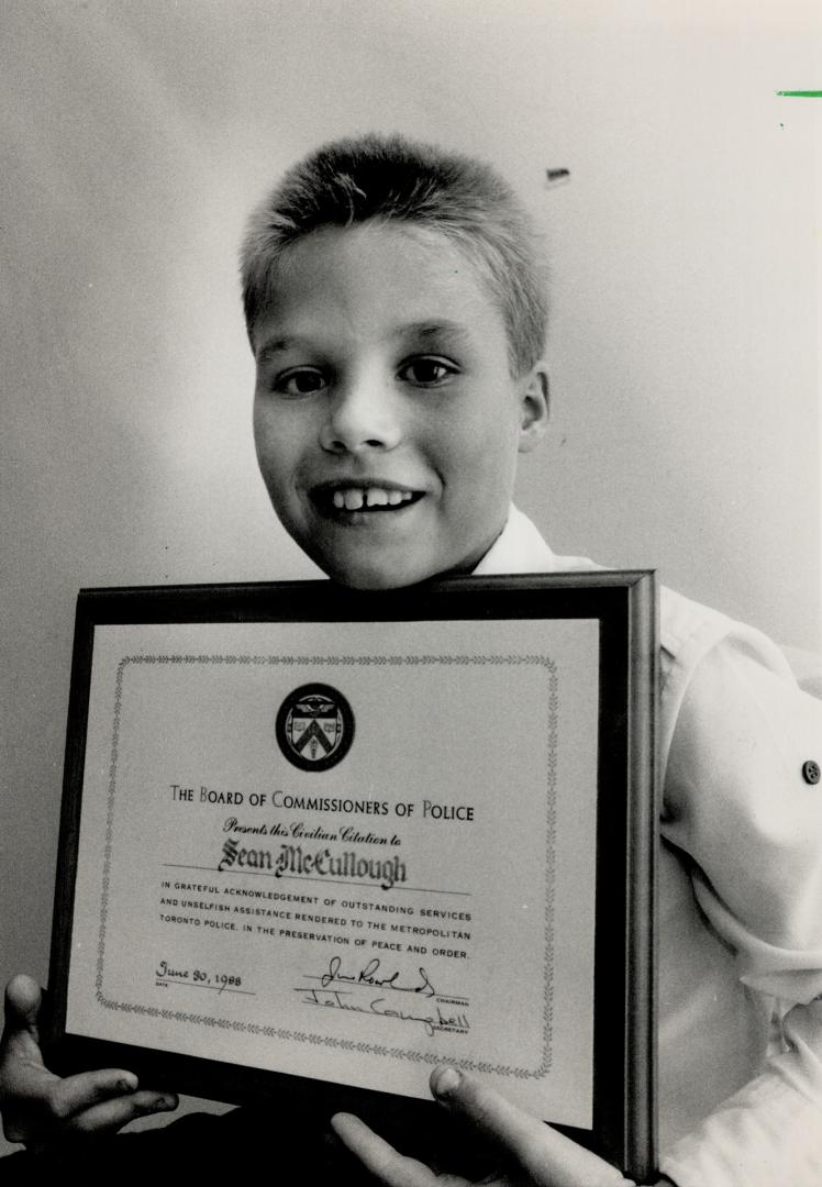 Foiled robber: Shawn McCullough, 11, of Etobicoek with police award he received because his description led to a thief's arrest.