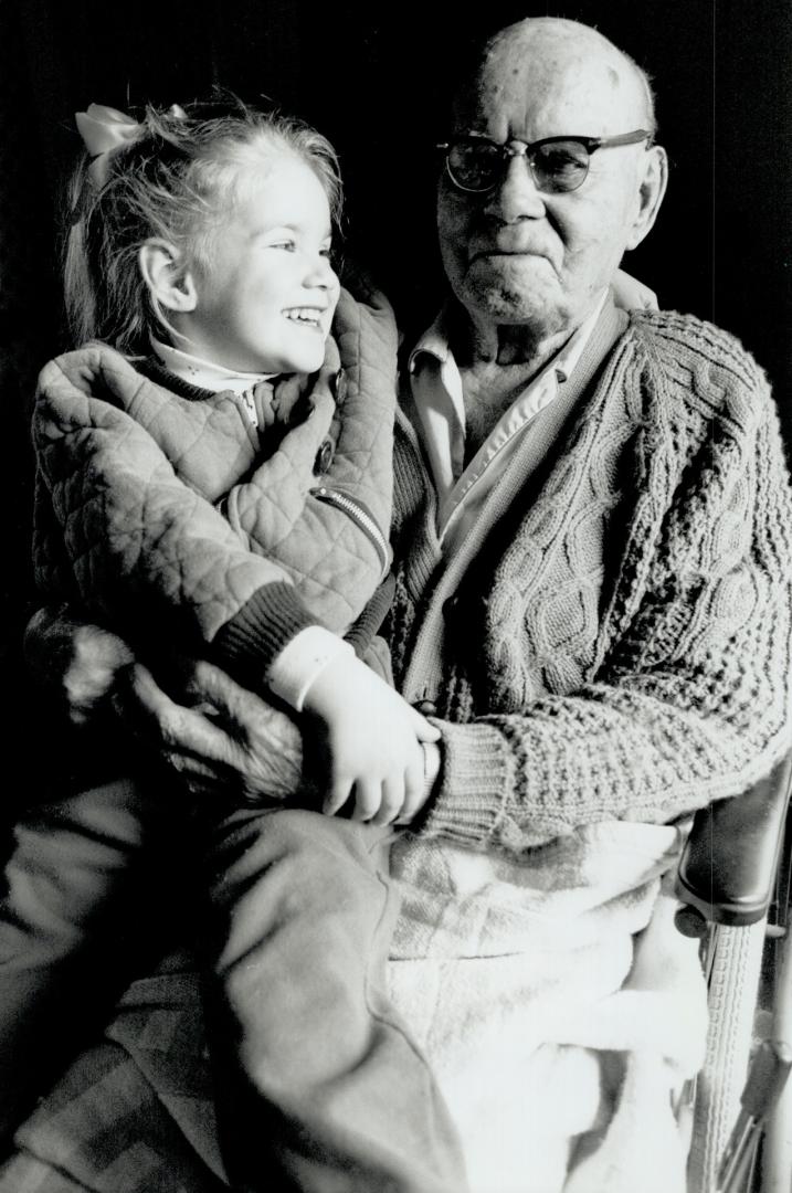 Proud centenarian: Retired Toronto police sergeant James McCrackan, with great-granddaughter Kartie Arnett, 4, celebrates his 100th birthday Wednesday