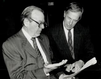 Debt conference: Don McGvierin, left, governor of The Bay, and George Kosich, president, confer at a shareholders' meeting yesterday