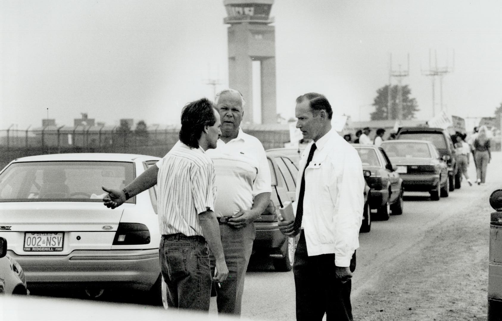 Airport Woe: Ducan McLeod, left, president of the air traffic controllers union, talks with traffic control manager Harold Martin, right, and a Peel Region police officer at Pearson airport today