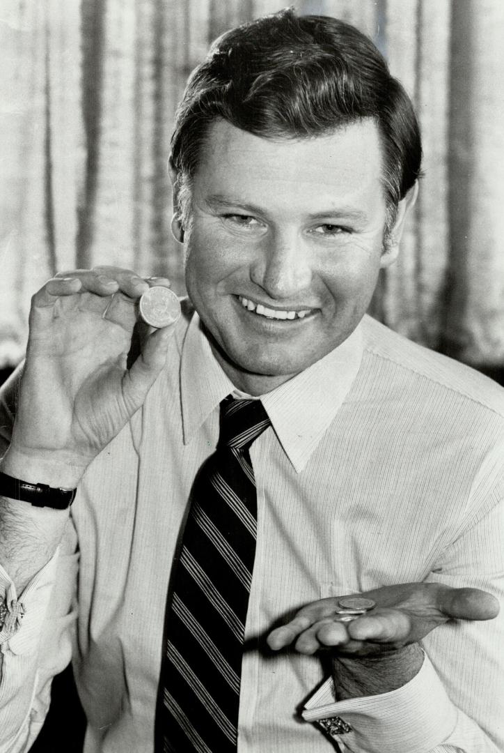 Krugerrand for the masses: Donald Mackay-Coghill, head of South Africa's International Gold Corporation, seller of the popular krugerand, shows the new, smaller version of the gold coin that is aimed at small investors for whom the original one-ouncer has become too expensive