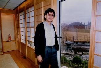 In contrast: Designer Jack McDonnell, above, leans on a traditional wing chair and Nicolas Sum Stands by the shoji screen in his sitting room.