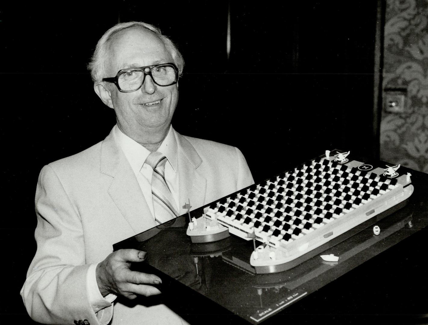 Floating idea: Harold Madill, who runs a Weston printing firm, holds a model of his concept for solar-powered tankers