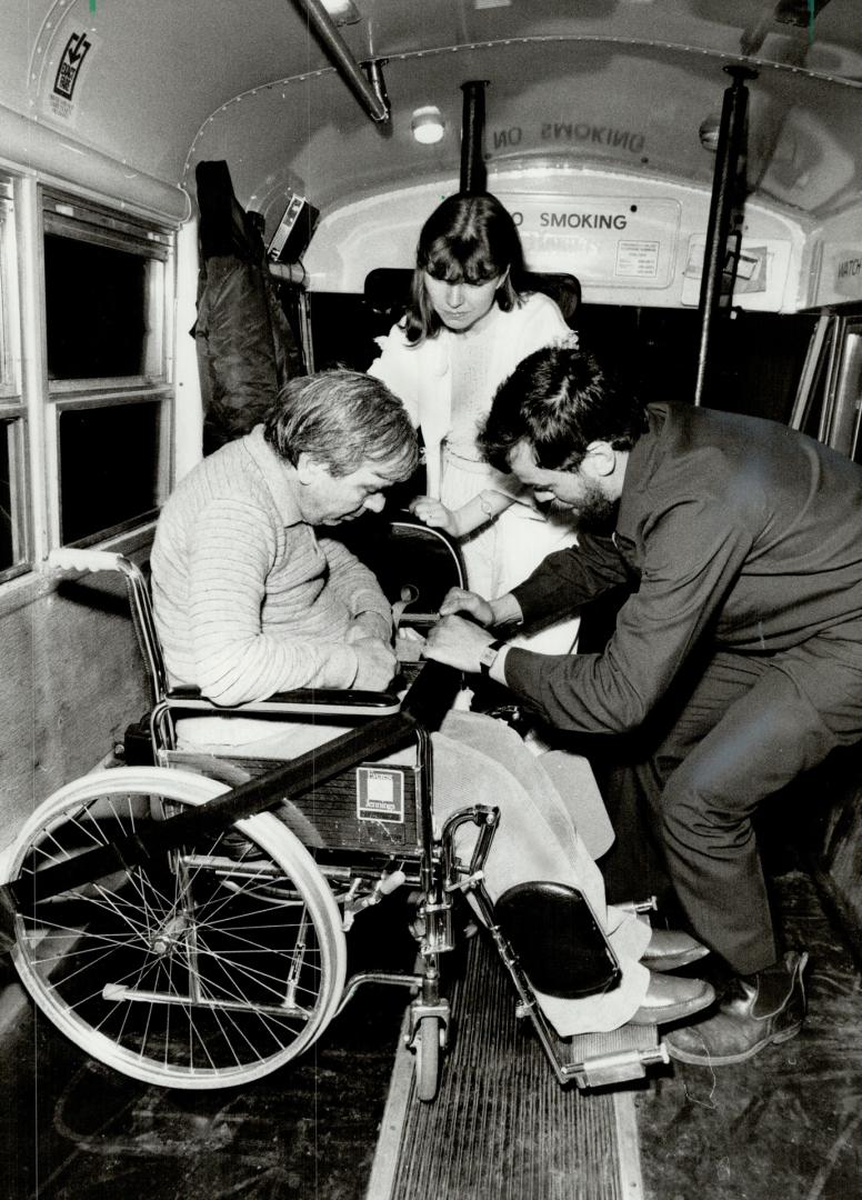 Going home: Wheel-Trans driver Ron Vaillancourt checks that Frank Mariani is safely strapped in as daughter Simonetta Mariani looks on