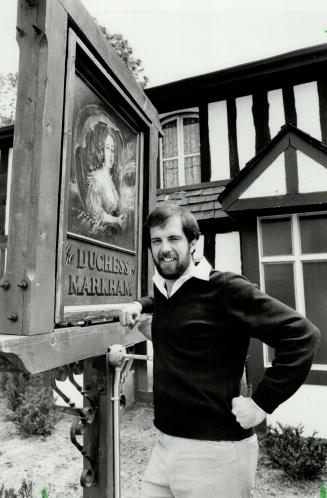 A new love: Former tennis teacher Ross Matheson stands by sign outside restaurant and tavern he opened with partner Diane Gilliland