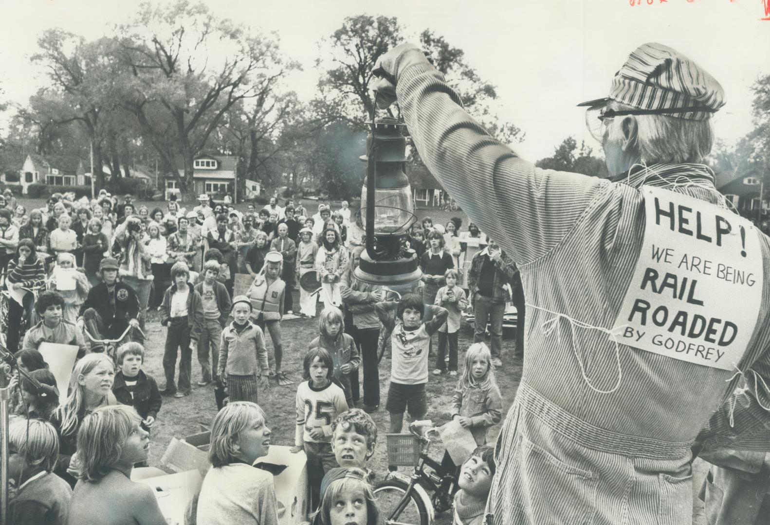 In Railroad clothes, Bill Metcalf makes a speech to fellow residents of Ward's Island at their picnic-party yesterday celebrating the second year they have stayed on the Islands since Metro finally ordered them off