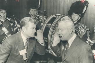 One-time argo halfback and footfball referee Johnny Munro (left) give the go signal to opena convention of life insurance executives yesterday - with the loud help of the loud help of the Metro police pipe band