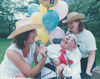 Double Celebration: Ingrid Navidad, left and Jana Manolakos sing some country songs to Frank Myers, 70, who marked his 40th years yesterday as a patient at Queen Elizabeth Hospital