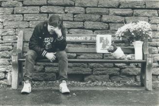 Makeshift shrine: Man cries on Yonge St. city bench where people have left flowers for Gordon Napier, who died earlier this week.