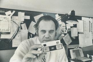 Tired of seeing his advertising brochures end up in the waste basket, advertising man Gunter Nerlich has come up with a patented three-dimensional viewing device, which he is holding, above