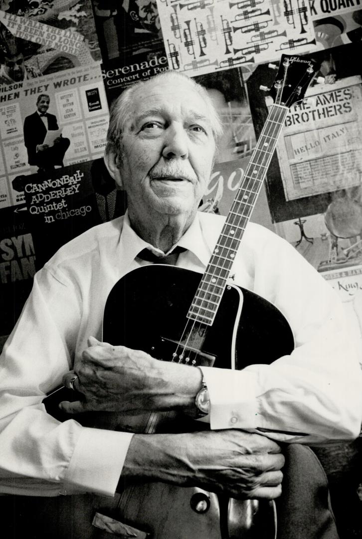 Seniors' band: Retired neurologist Dr. John Maxwell, 80, leader of Dr. John's Big Band Sound, poses with his quitar in front of a wall in his home covered with record album covers. The 16-piece band - alll but two of the members are retired - plays for seniors and at chartiable events.