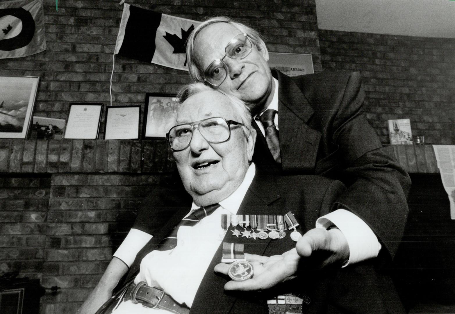 War Hero: Milo Vassalo of the Maltese Consulate gives Alexander Milne, 81, a congratualtory hug after presenting him with the Maltese George Cross for bravery as an RCAF pilot during World War II