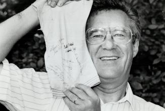 On 45th anniversary of the end of World War II, David Michell holds patch of parachute signed by American Gls who liberated Weihsien camp, right.