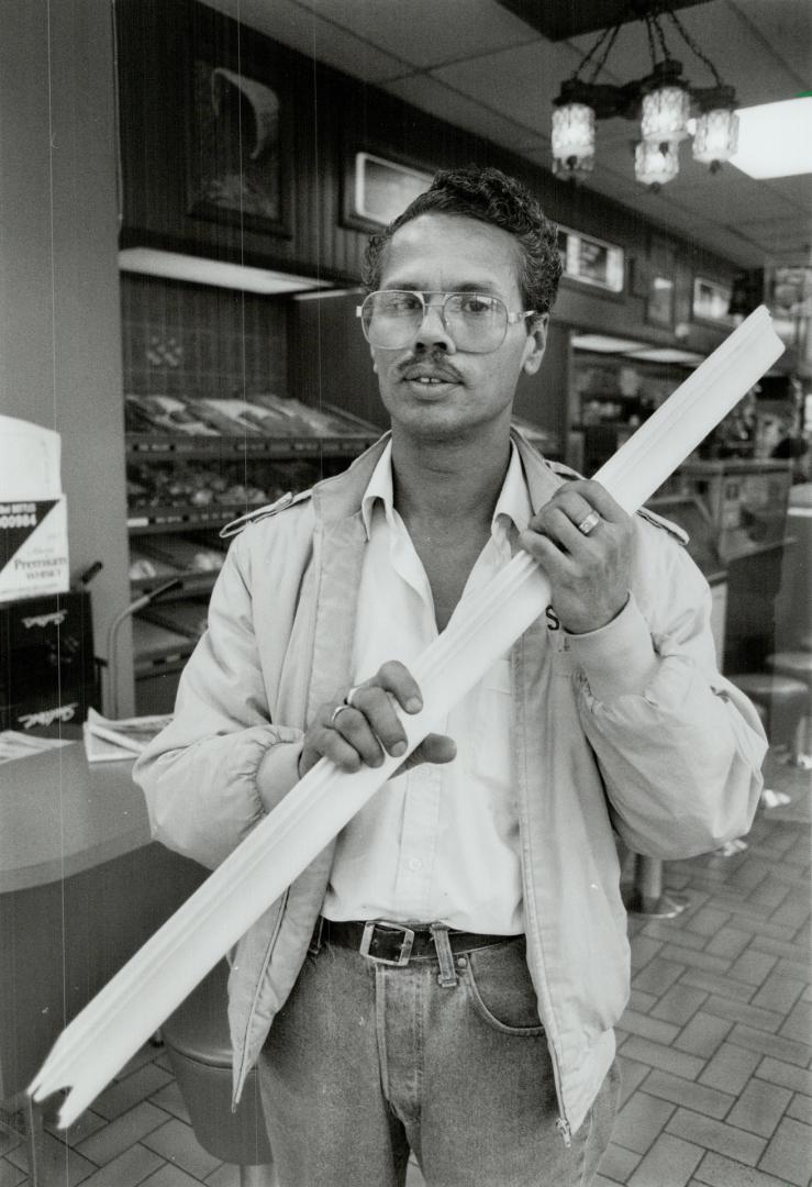 Makeshift weapon: Taufique Mohammed holds broken board, one of several weapons used to damage his store and terroize staff and customers.