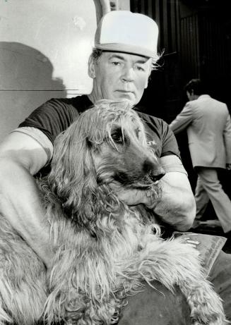 Shady affair: John Mucenieks and his pet, Milk Bone, were not at all happy today after the city dismantled the dog's street-corner shelter