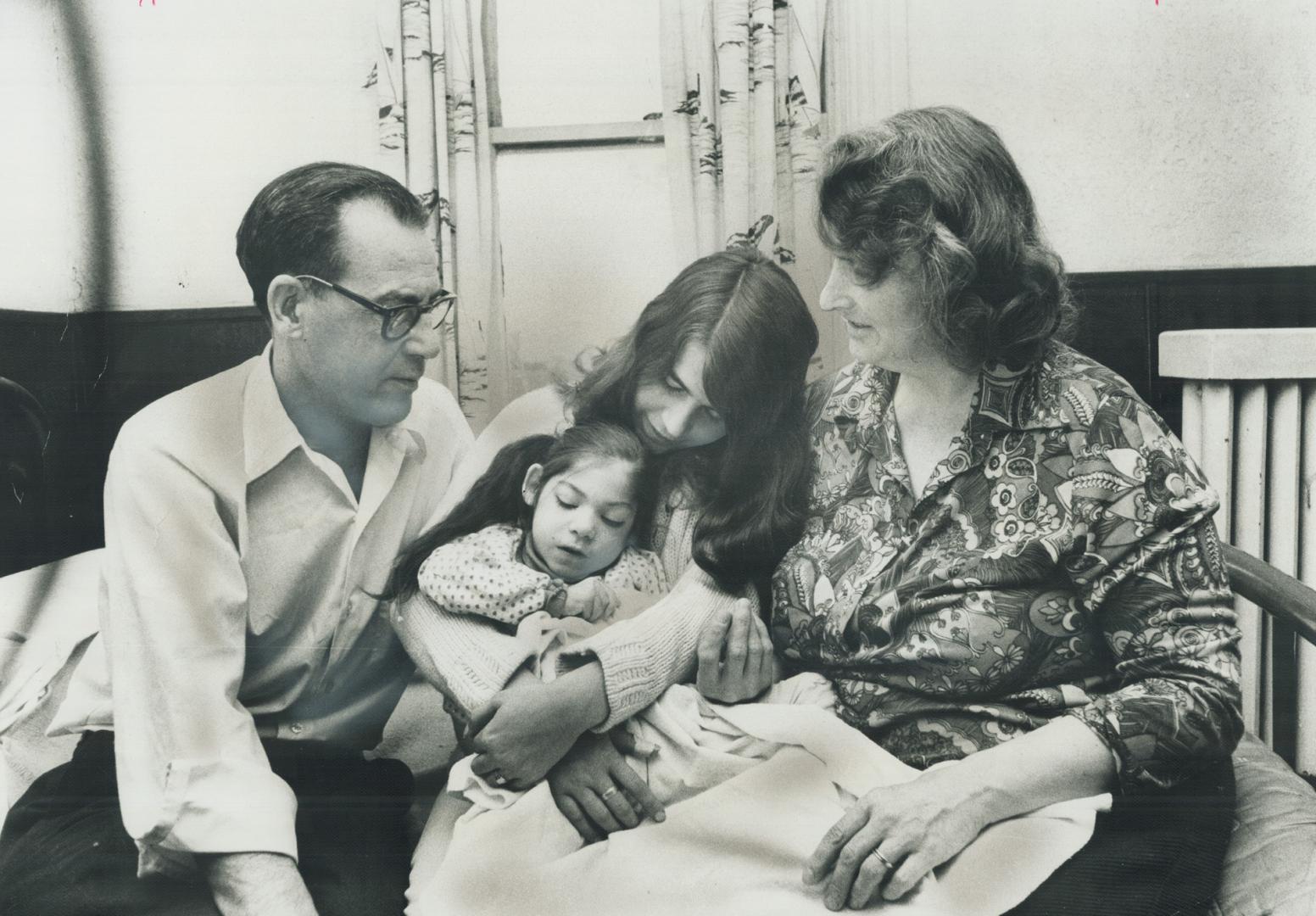 A family without a home, John Edward Norton sits with his wife, Annie Mae, and 17-year-old daughter Greer who holds their 9-year-old daughter Alwyne, a cerebral palsy victim, in one of the three crowded rooms on the third storey of the Gilbert Hotel in downtown Trenton