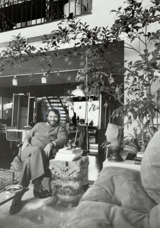 Ancient charm: Robert Noakes sits in one of his few chairs not covered with art books. To his left is a 1,200-year-old capital.