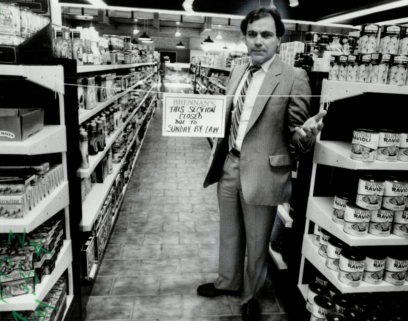 Frustrated: Max Orticello, director of the firm that owns Brenan's Gourmet Foods, shows how he's had to rope off half the store to comply with the provincial law governing store openings