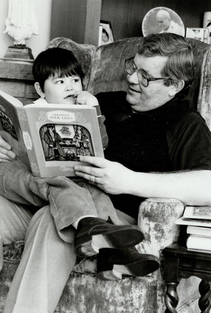 Bedtime treat: Ted Potochniak, 42, who has a strong interest in his Ukrainian cultural heritage and a love of the ancient tradition of storytelling, reads Ukrainian folk tales to his son, Michael, 5 in their Weston home