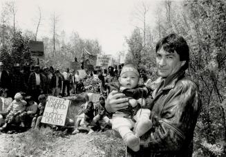 Fighting for future: We have been here 6,000 years and plan to be here 6,000 more years, said Chief Gary Potts, with grandson at roadblock last summer, when band members blocked a logging road to a forest which they said included sacred grounds