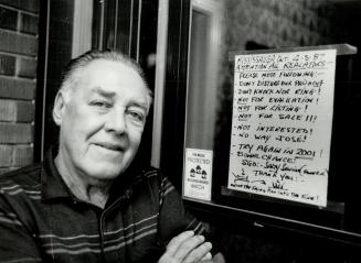 No sale: Frank Pougnet stands beside the sign he has put up on his Mississauga door to discourage real estate agents from offering to sell his house which backs on to a golf course near Dixie