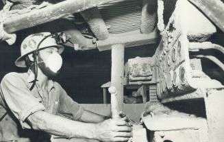 Below the praries. Don operates giant drilling machines wearing mask to protect against dust.