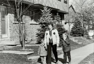 Hanging in: Audrey Reid and sons Mike, 2, and Steve, 5, take a stroll through the Brampton AHOP-development where they live.