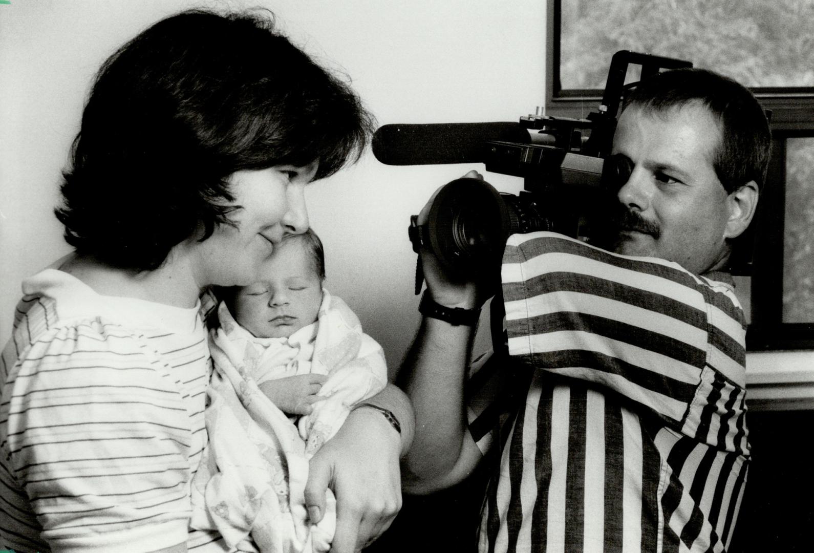 His mentor: One-armed fencer Francois Roeder, who helped Gary Rangasamy overcome some fears about having his arm amputated, videotapes wife Karen, and 2-week-old son Sebastien