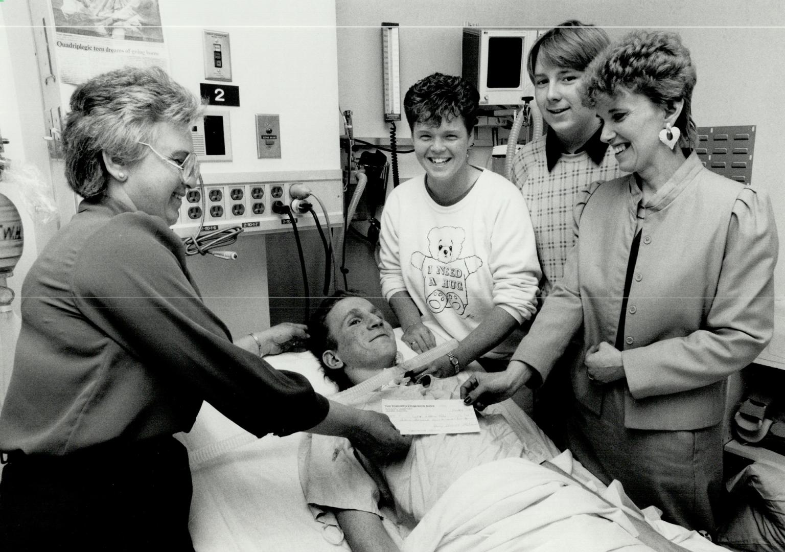 Helping hand: Gail Ivison, right, and her son Thom, beside her, presented a cheque for $18,500 to Jack Riley, 17, yesterday at Toronto Western Hospital, bringing smiles to the faces of Jack's mother, Delores, left, and his sister Adele