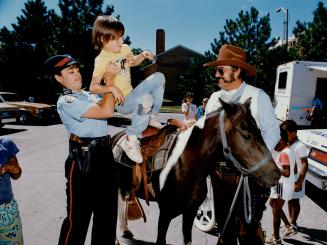 Treat for kids: Jason Jackson, 8, gets a lift from Constable Tina Tirabassi on to Say No