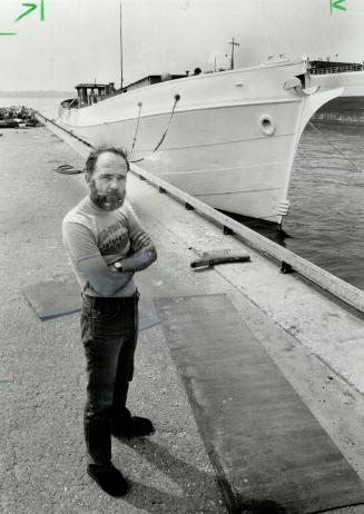 Schooner-to-be: Norman Rogers stands in front of his dreamboat, an old tug which he is transforming into a schooner at the foot of Sherbourne St