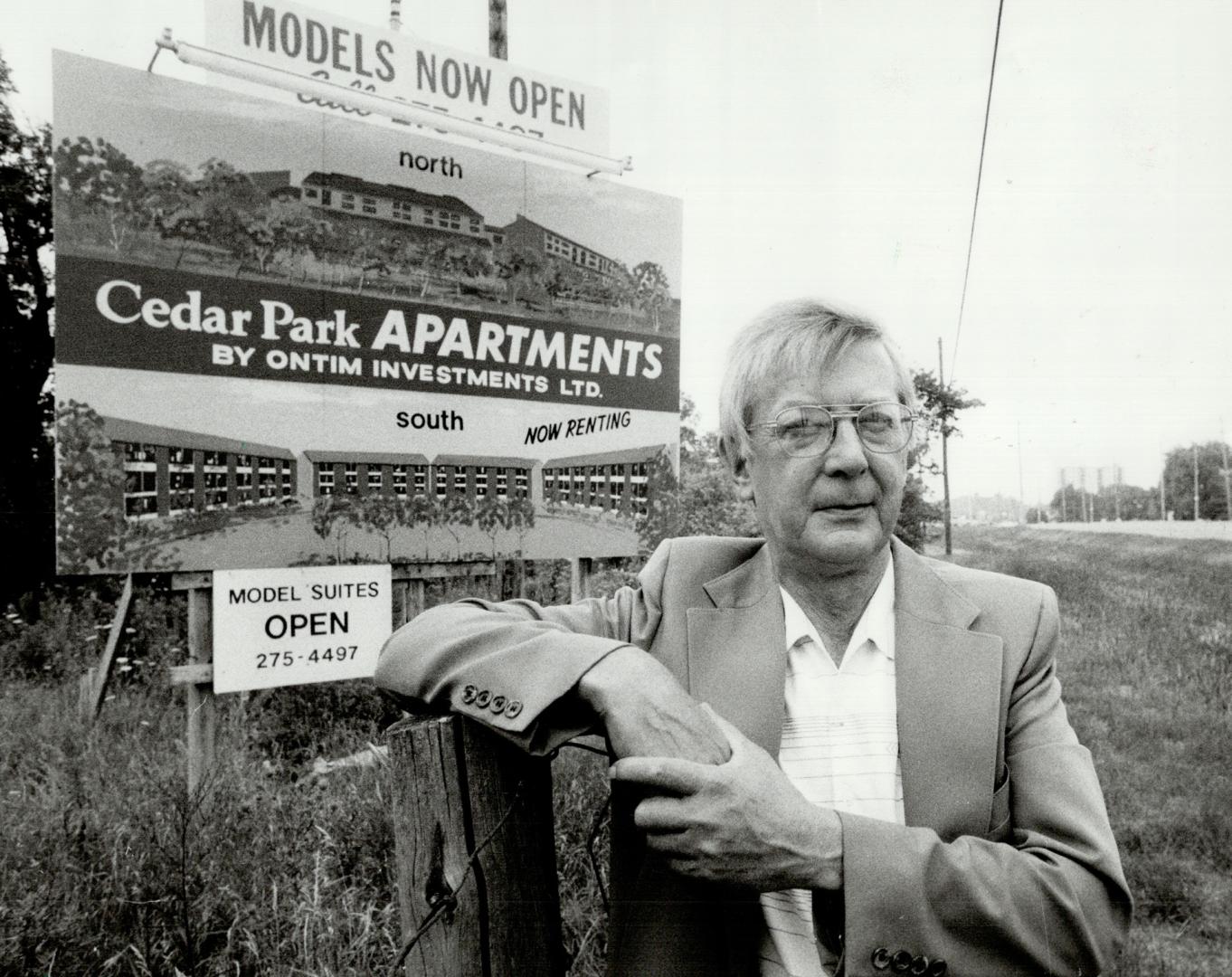 Growing pains: Roy Saari, president of Ghensharon Residents Association, stands beside a sign touting a new residential development on Dundas St