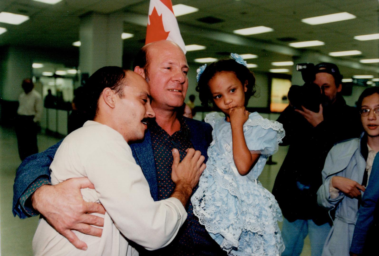 Cuban Reunion, Ismael Sambra, centre, enjoys an emotional reunion with his son Guillermo and Granddaughter Yessica, 5, after their arrival at Pearson airport yesterday from Cuba