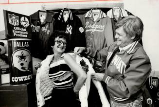 Ben Shain, wearing Cincinnati jacket, helps his wife Eleanor into Leafs jacket.