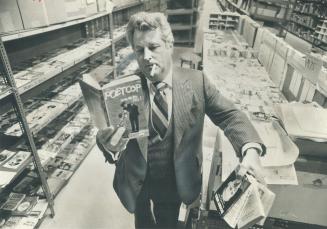 Sampling the goods: Jim Smallwood, president of Simon and Schuster of Canada, thumbs through some of the paperbacks in his warehouse at Steelcase Rd