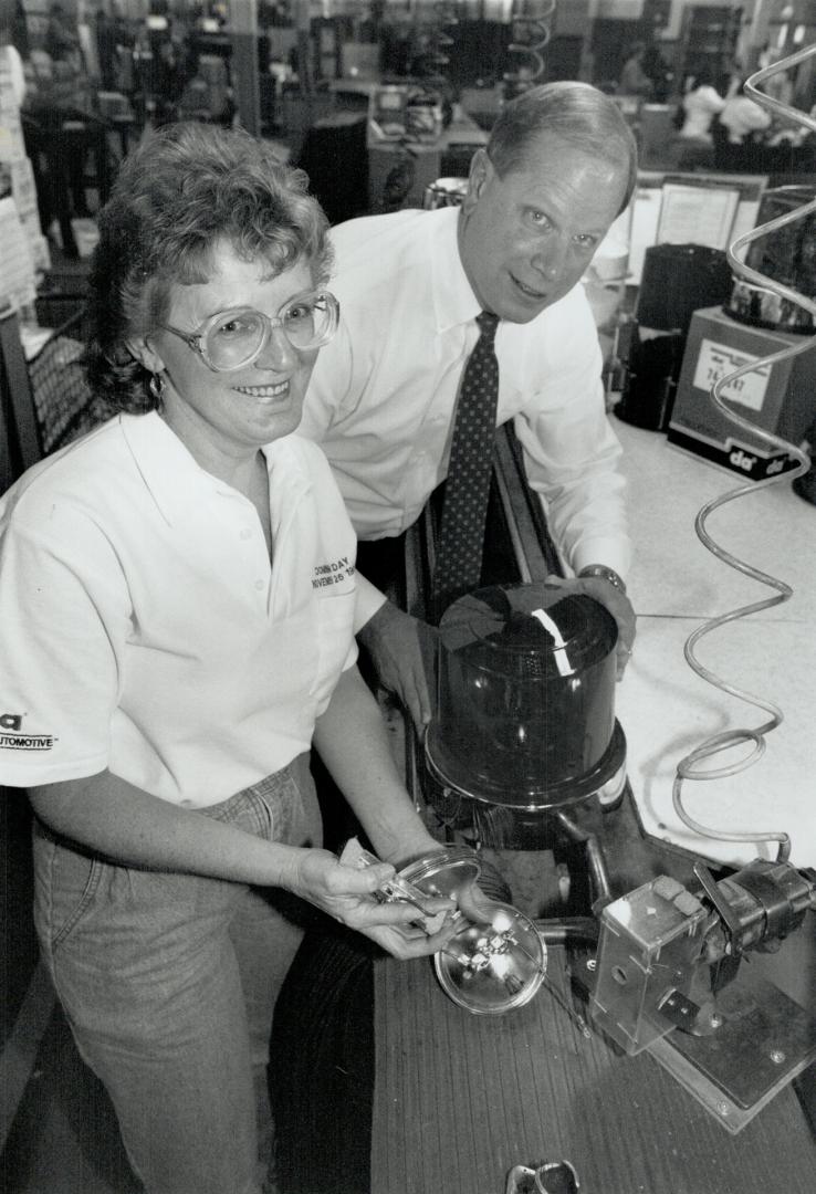 President Cle Smith watches Linda Cameron work on the top line of revolving lamps for utility vehicles, above. Below, new owner Stephen Dent.