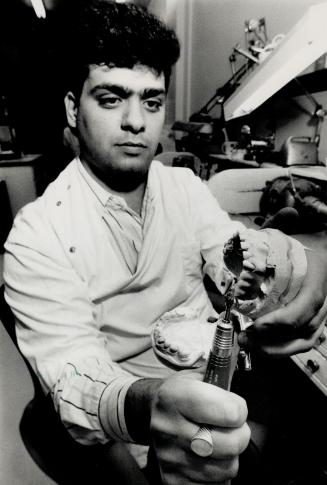 Molar mechanic: Carl Soscia, son of the owner, shapes a set of dentures at Soscia Casting Labs, 895 Wilson Ave