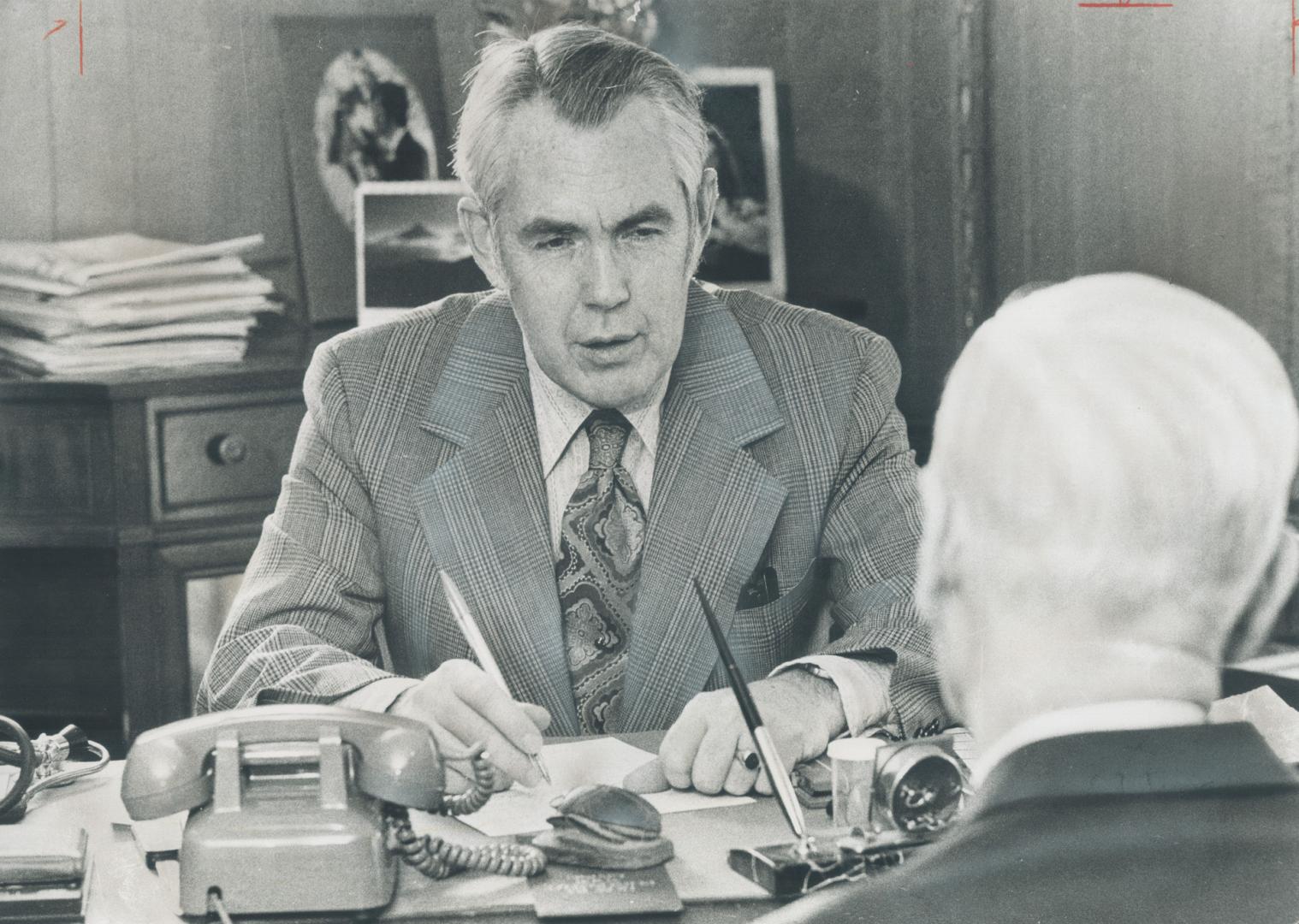 Robert Stephens cosults with a patient in his office. During one weekend, Dr. Stephens talked by phone with 40 patients, was six in his office, visited eight at home and three in hospital, all at about a $3 hourly rate. Not rapacious for overtime work, he says.