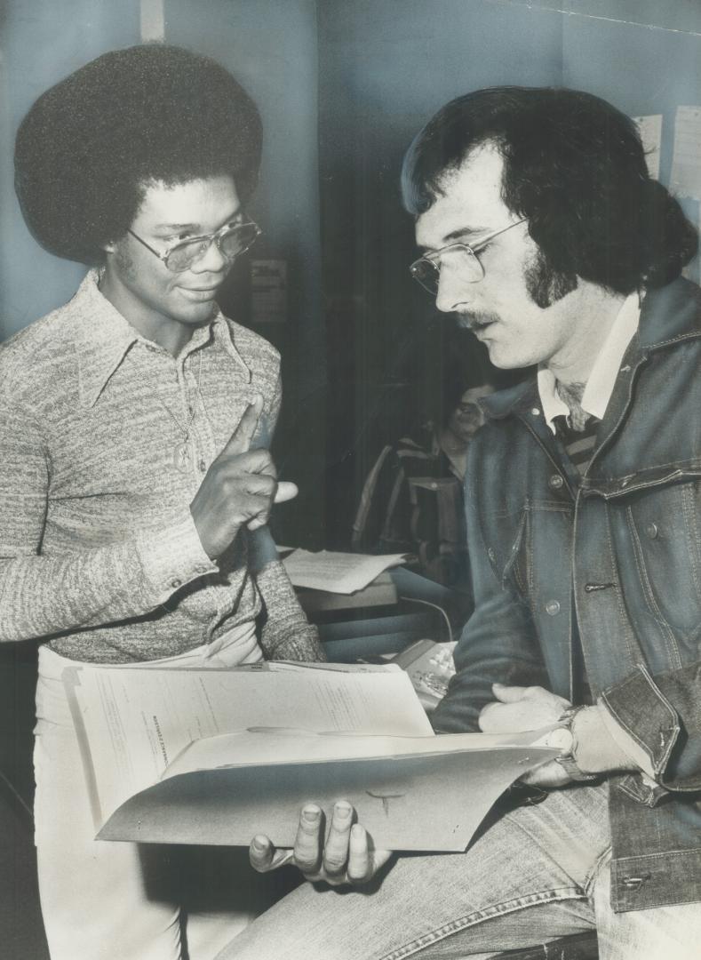 Paul stott, right, who works for the Parkdale Community Legal Sevices, discusses a problem with Cecil Pickering, whom he is helping with an immigration case