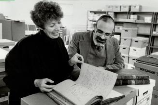 Moments of history: Stephen Speisman, director of the Ontario region Jewish archives, and assistant Brooky Robins look at minutes of a meeting that took place about 1899