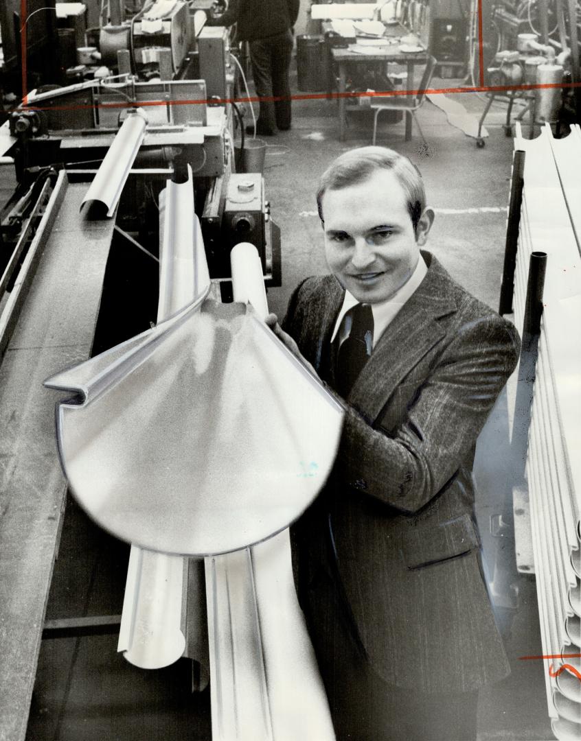 Jorgen Stolsgard inspects newly-produced vinyl eavestrough