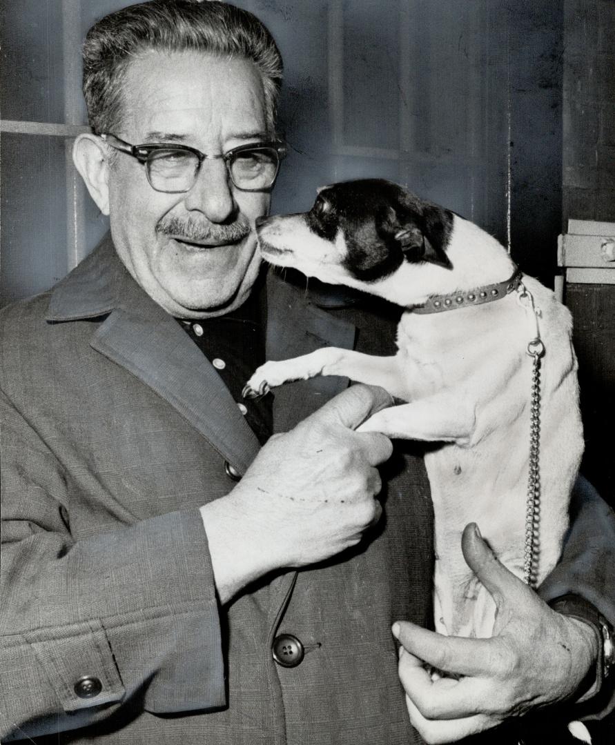 Bonnie, a terrier who's going on 15, licks the face of her master, Fred Straus, a Waterloo pensioner who went to jail rather than buy a dogtag for her