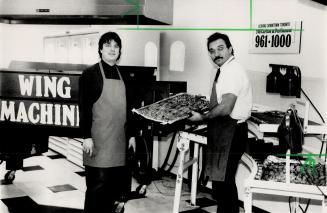 Wing maker: Tibor Szakall, one of the partners in The Wing Machine, holds a tray of baked wings produced at the partners' store on Carlton St.