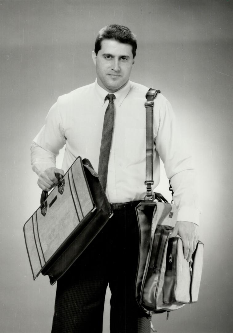 Career change: Phil Tamburino, a former physical education teacher, models his cork and leather garment bag, about $495 and document case, about $395