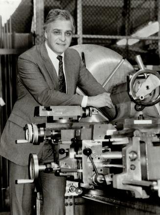 A helping hand: Baxter president John Thompson stands beside a manual lathe, the forebear of his new Future Builder, which will train students in computer-aided manufacturing