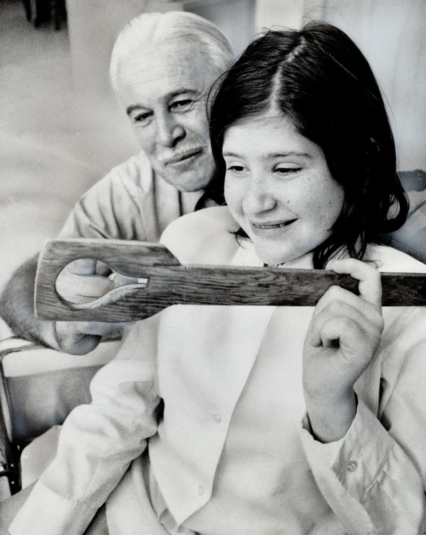 Confined to a wheelchair by a spinal disorder, 14-year-old Cathy Coles can turn water taps onand off with wooden tool Vic Thompson made for her