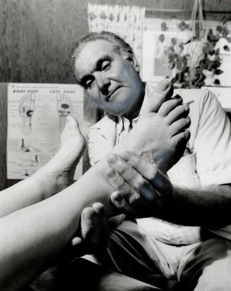 Healing hands: William Turkington, 58, of Oshawa applies pressure to different parts of the foot to determine if the rest of the body is healthy