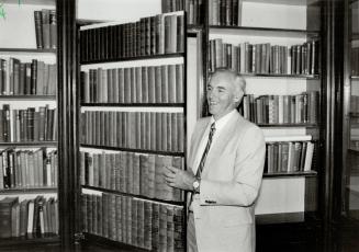 Above, in the logo, Horsted is seen from one side. At left Brian Turner, one of the owners, finds some delight in library's secret door.