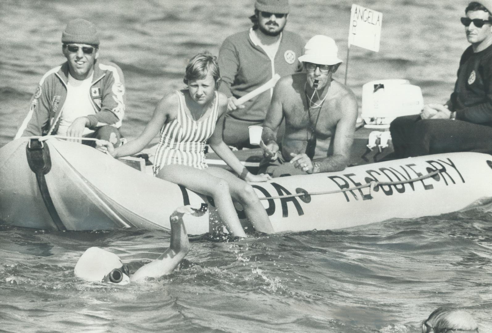 Showing concern, Cynthia Anigacz, a friend, and coach Art Dufresne (with whistle) watch from the escort boat as 14-year-old Angela Kondrak made her determined attempt to become the youngest person ever to swim Lake Ontario