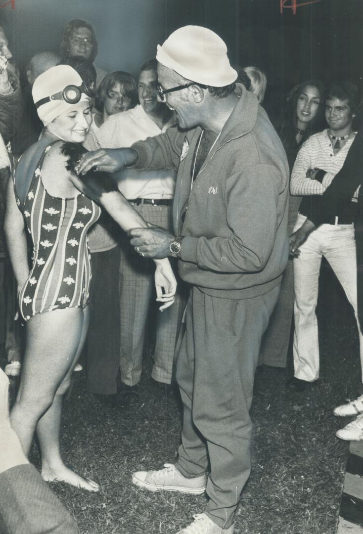 Greasing up for 32-mile swim across Lake Ontario, 14-year-old Angela Kondrak of the Borough of York is helped by her coach, Art Dufresne, last night at Youngstown, N